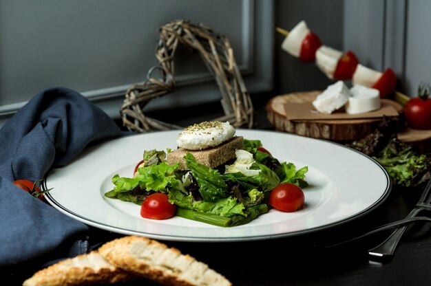 Fischkännchen mit Salat, Schwarzbrot und Tomaten