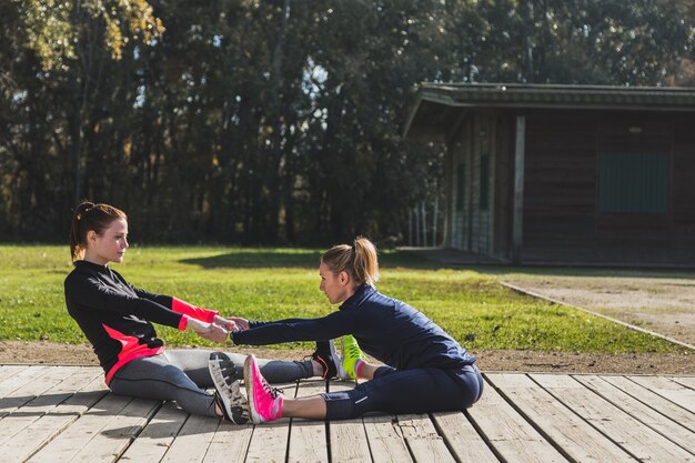 Fit Frauen Aufwärmen zusammen draußen