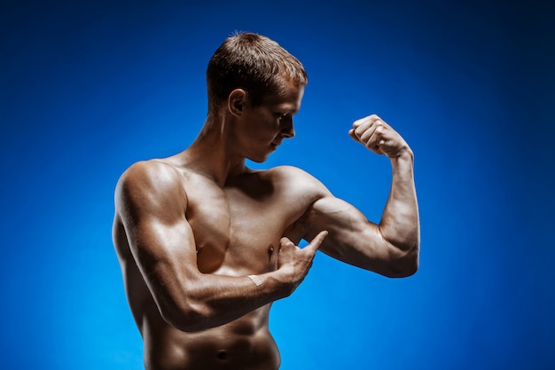 Fit junger Mann mit schönen Torso auf blau