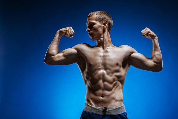 Fit junger Mann mit schönen Torso auf blau