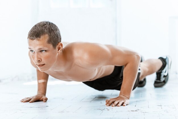 Fit Mann macht ein paar Liegestütze im Fitnessstudio