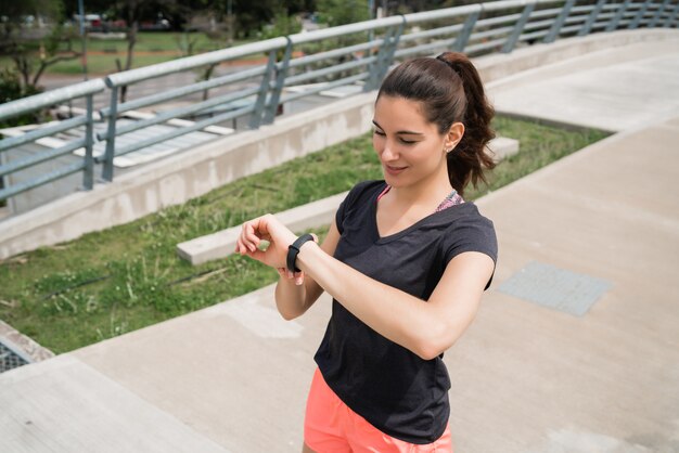 Fitness-Frau, die Zeit auf Smartwatch prüft