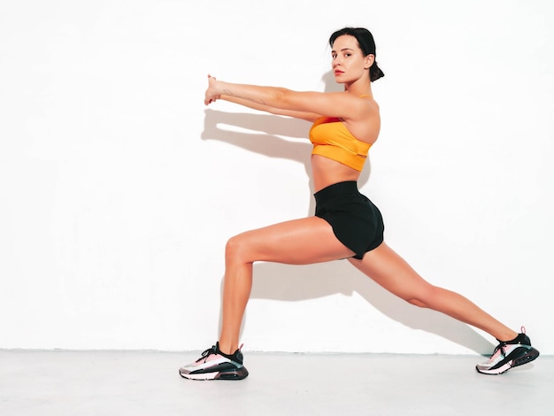 Fitness selbstbewusste Frau in Sportkleidung Sexy junges schönes Modell mit perfektem Körper Weibliche Aufstellung im Studio Stretching vor dem Training