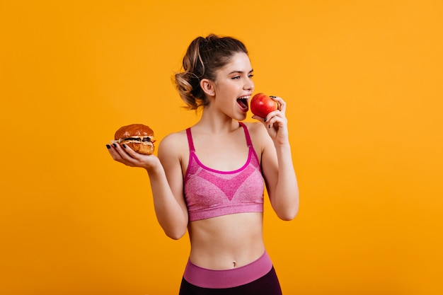 Fitnessfrau, die roten Apfel isst