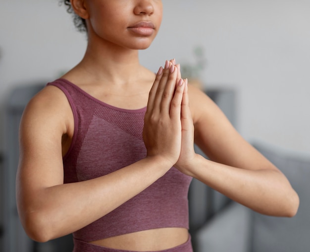 Fitnessfrau, die Yoga auf einer Yogamatte zu Hause tut