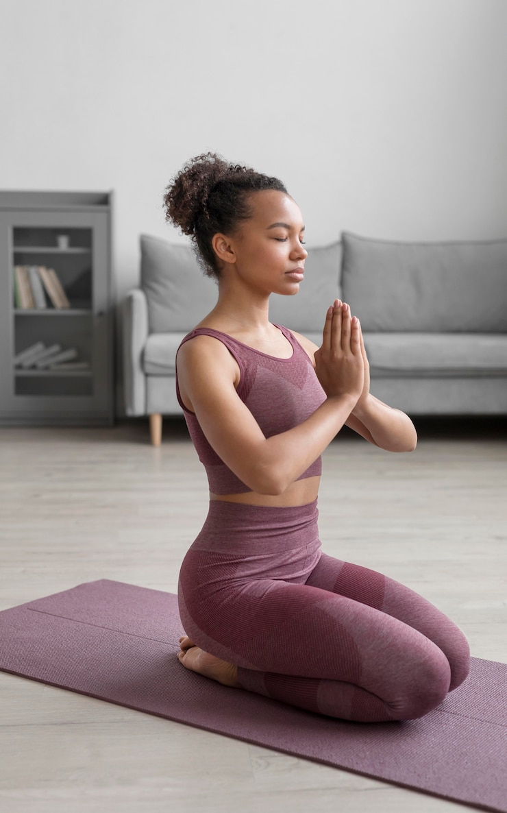 Kostenlose Foto fitnessfrau, die yoga auf einer yogamatte zu hause tut