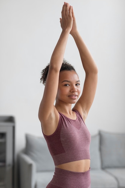 Fitnessfrau, die Yoga zu Hause macht