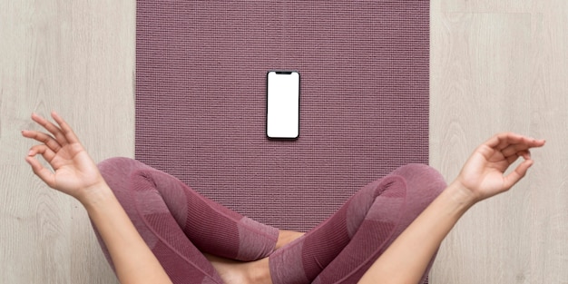 Kostenloses Foto fitnessfrau mit einem smartphone mit leerem bildschirm