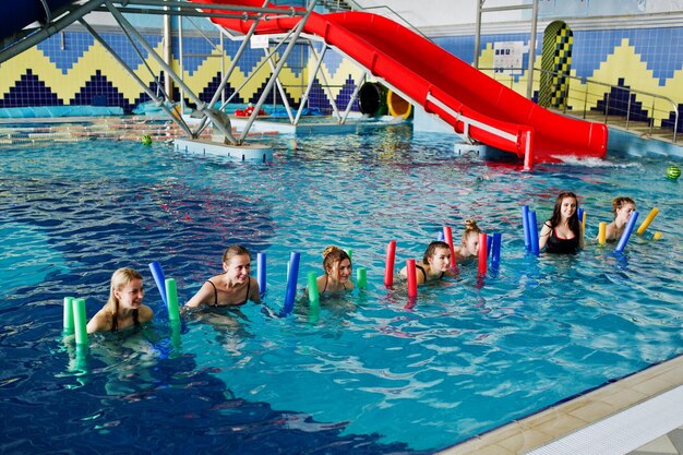 Fitnessgruppe von Mädchen, die Aerobic-Übungen im Schwimmbad im Aquapark machen Sport- und Freizeitaktivitäten