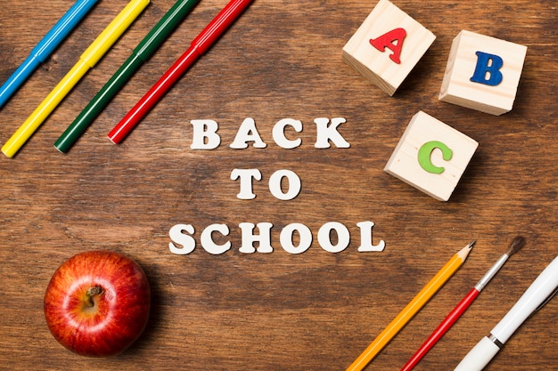 Flach auf dem hölzernen Hintergrund zur Schule zurückgelegt