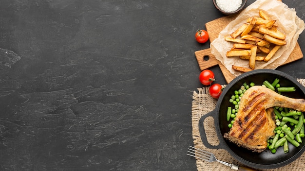 Flach gebackenes Hähnchen und Erbsenschoten in eine Pfanne mit Kartoffeln und Kopierraum legen