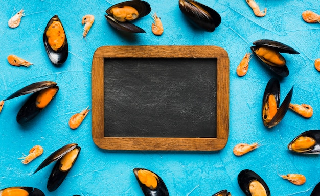 Kostenloses Foto flach gelegte gekochte miesmuscheln mit tafel