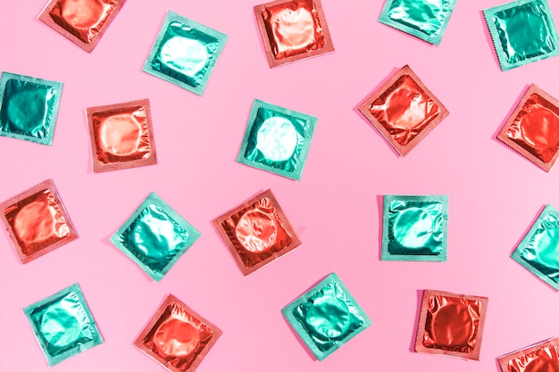 Flach gelegte Kondome in roten und grünen Hüllen