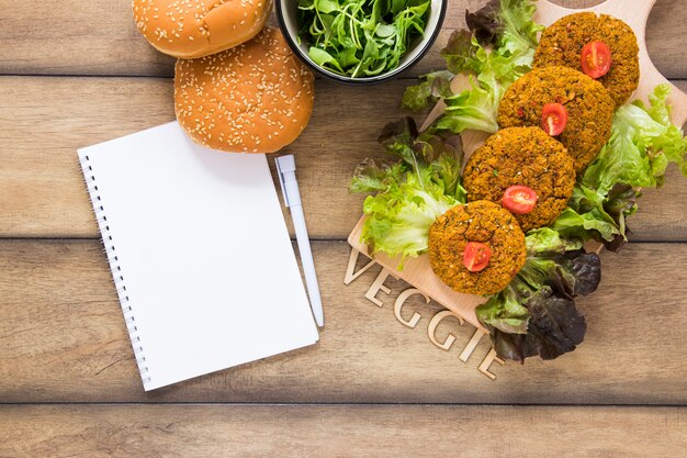 Flach gelegte vegane Gerichte neben dem Notebook-Modell