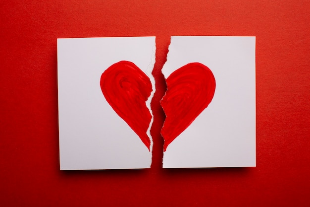 Flach gelegtes zerbrochenes Papier mit rotem Herzen