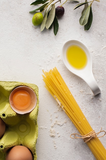 Flach lag ungekochtes Spaghetti Olivenöl und Eier