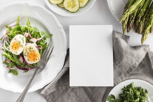 Flach leckeren Salat auf einen weißen Teller mit leerer Karte legen