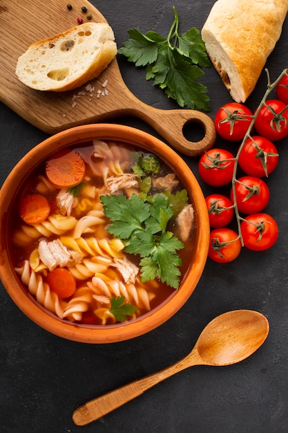 Flach legen Sie Brokkolikarotten und -fusilli in der Schüssel mit Brot auf Schneidebrett und hölzernem Löffel