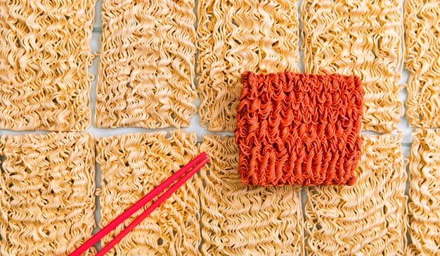 Flach legen Sie grundlegende Ramen mit roten Nudeln