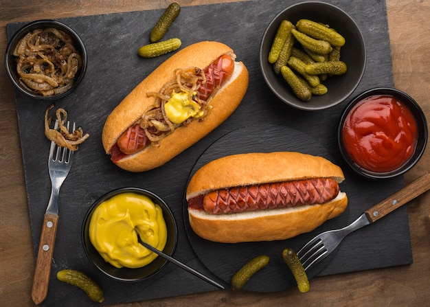 Kostenloses Foto flach liegende hot dogs und gewürzarrangements