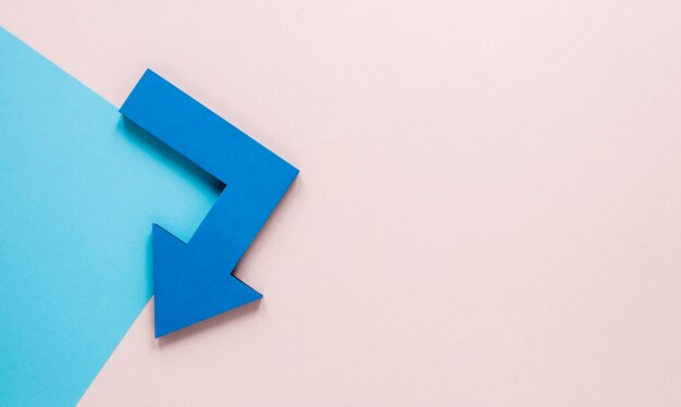 Flache blaue Pfeile und blaues Pappmodell legen auf rosa Hintergrund mit Kopierraum