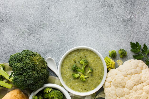 Flache Brokkolibiskuitcremesuppe und -blumenkohl in der Schüssel mit Kopienraum