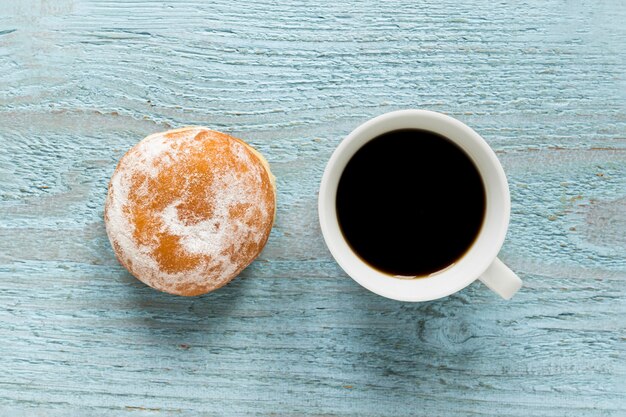 Flache Donut mit Kaffee auf Holzoberfläche