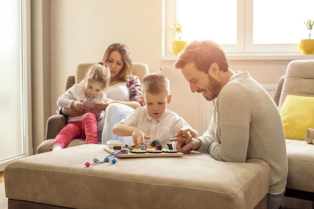 Flache Fokusaufnahme einer glücklichen kaukasischen Familie, die liest und spielt