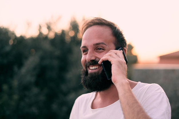 Flache Fokusaufnahme eines jungen Kaukasiers, der am Telefon spricht