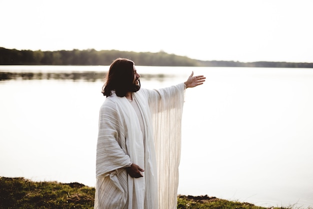 Flache Fokusaufnahme von Jesus Christus mit erhobenen Händen und Blick in die Ferne