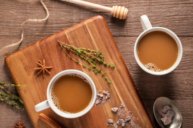 Flache Kaffeetassen auf Holzbrett legen