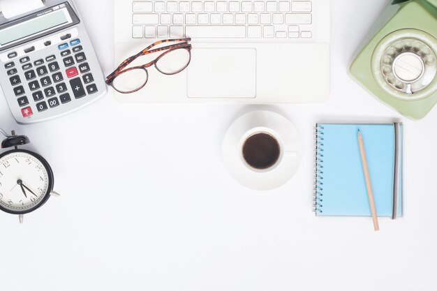 Flache Lage Arbeitsbereich Schreibtisch mit weißem Laptop, Schreibwaren und Tasse Kaffee