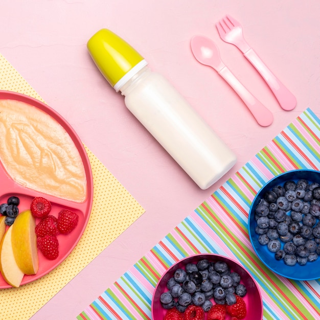 Flache Lage der Babyflasche und des Essens mit Früchten