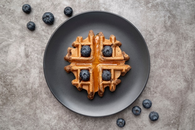 Kostenloses Foto flache lage der waffel auf platte mit blaubeeren