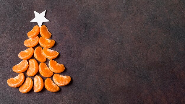 Flache Lage der Weihnachtsbaumform machen von Mandarinen mit Kopienraum