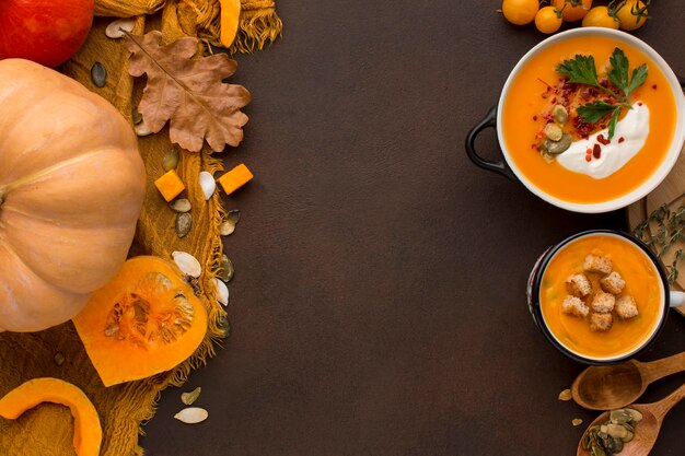 Flache Lage der Winterkürbissuppe in Schüssel und Becher mit Kopierraum und Croutons