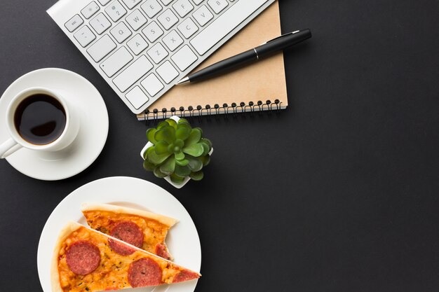Flache Lage des Desktops mit Pizza und Kaffeetasse