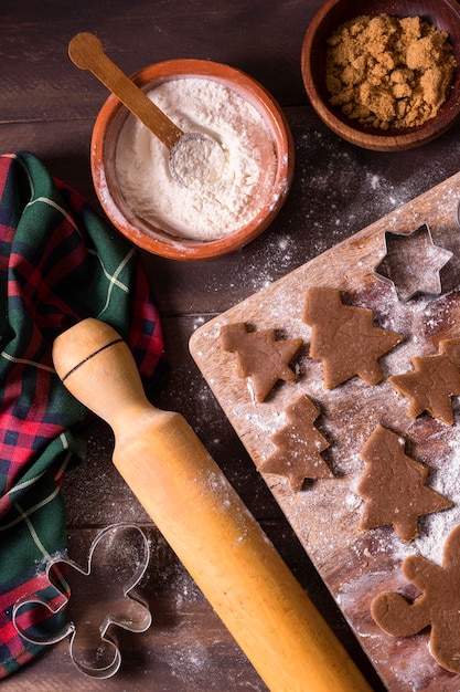 Flache Lage des Weihnachtsplätzchenteigs mit Weihnachtsbaumformen