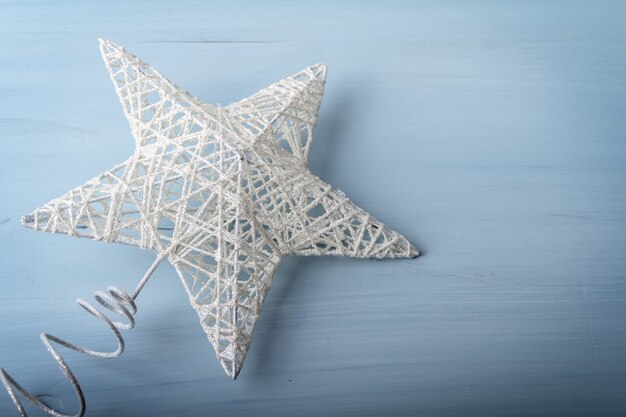 Flache Lage des weißen Weihnachtsspielzeugs in Form eines Sterns auf hölzernem Hintergrund