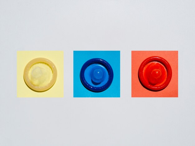 Flache Lage farbige Kondome auf weißem Hintergrund
