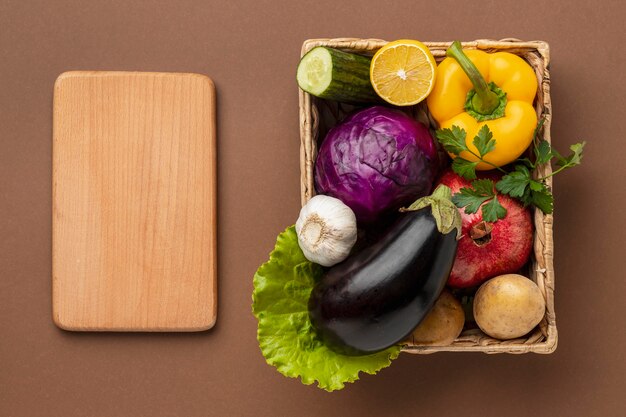 Flache Lage Korb mit frischem Gemüse mit Schneidebrett