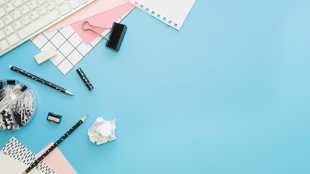 Flache Lage von Büromaterial mit Tastatur und Bleistiften