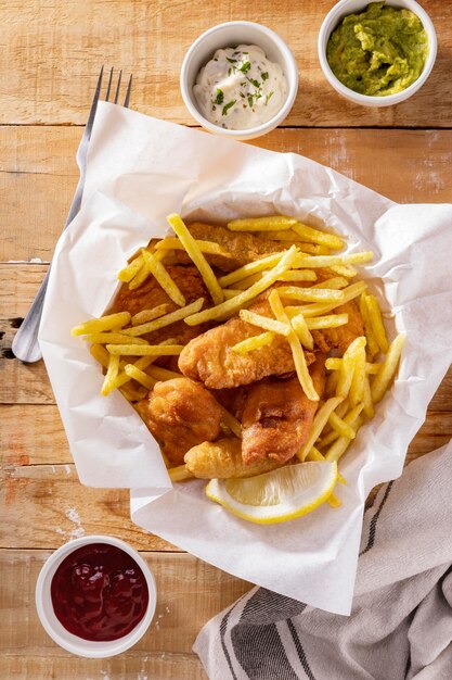 Flache Lage von Fish and Chips mit Saucen