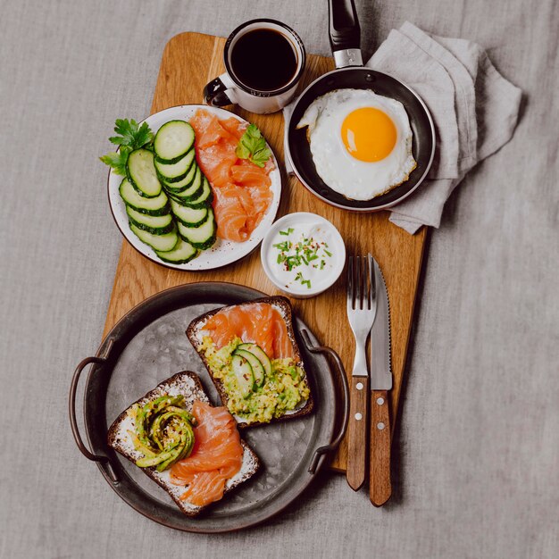 Flache Lage von Frühstücksbrötchen auf dem Bett mit Spiegelei und Toast