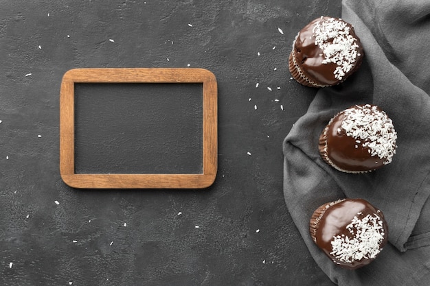 Flache Lage von Schokoladendesserts mit Tafel