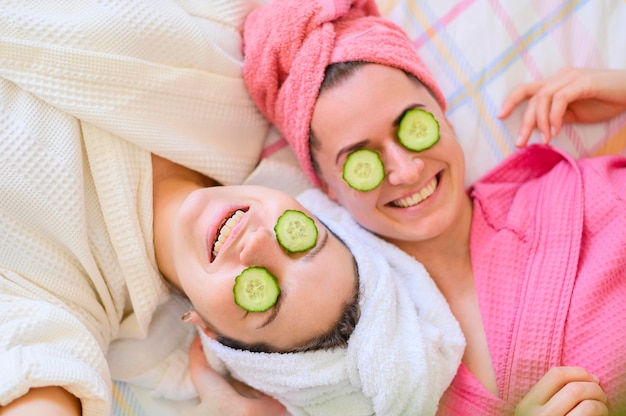 Flache Lage von Smiley-Frauen mit Gurkenscheiben auf den Augen