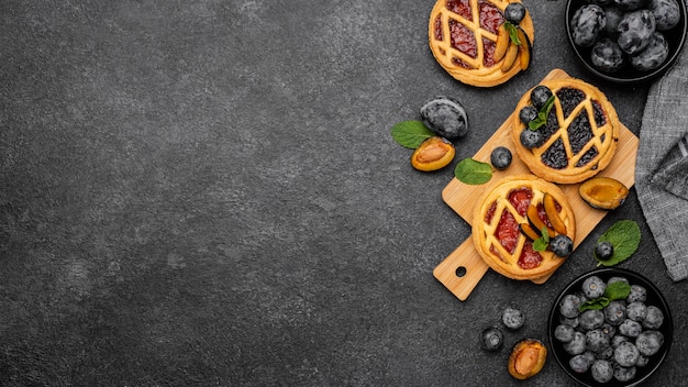 Kostenloses Foto flache lage von süßen kuchen mit früchten und kopierraum