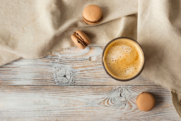 Flache Lage von Tasse Kaffee und Macarons