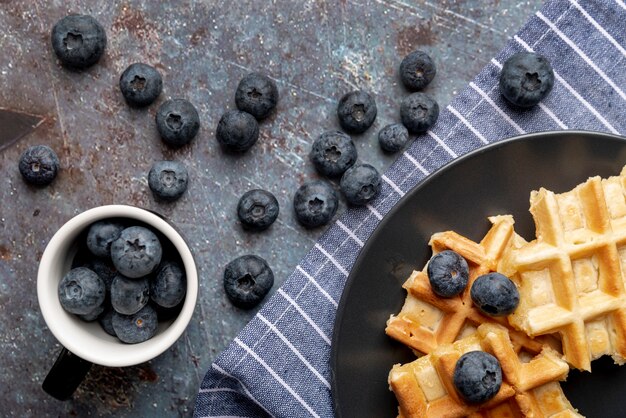 Flache Lage von Waffeln und Blaubeeren auf Platte