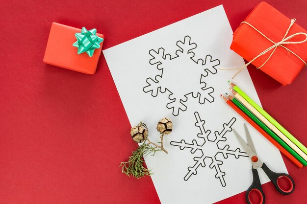 Flache Lage von Weihnachtsfiguren zum Färben und Trimmen auf Rot